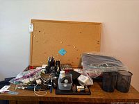 Overall lot on desk showing cork board and assorted office supplies