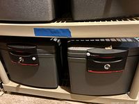 Two SentrySafe chests side by side on shelf