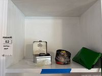 Shelf view showing both watch tins and green pouch