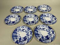 Eight blue and white Mikado plates laid out