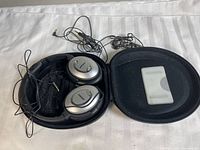 Headphones inside open case with cable and instruction card visible
