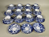 Group of twelve teacups and fifteen saucers arranged