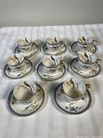 Group shot of eight demitasse cup and saucer sets