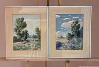 Two framed watercolor landscapes side by side on easel