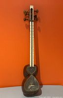 Full view of Persian tar against orange background