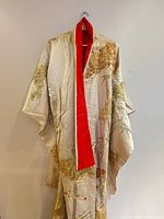Front view of cream kimono with red collar showing gold embroidery