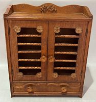 Front view closed showing double doors, rosette carvings, drawers