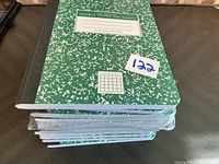 Stack of green marble cover quad ruled notebooks