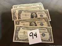 All five $1 silver certificates stacked showing fronts