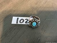 Top view of sterling silver ring showing turquoise cabochon and cluster setting