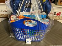 Overall view of basket wrapped in plastic with backpack and supplies visible