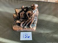 Front view of cast iron Minute Man bank with number tag