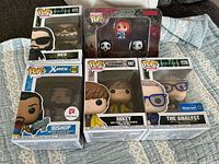 Group shot of five boxed Funko figures on quilt