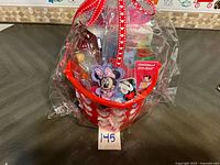 Full view of wrapped gift basket showing bucket and ribbon