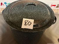 Full view of lidded speckled pot with lot number