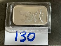 Full view of silver bar in plastic holder showing eagle design