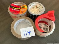 Four tape rolls grouped, showing labels and dispenser