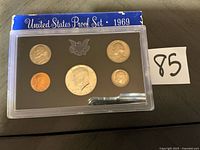 Front view of 1969 U.S. Proof Set showing five coins in sealed holder and outer sleeve