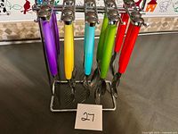 Front view of full utensil set on rack showing handle colours