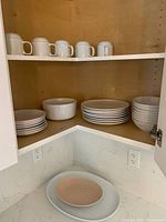 Cabinet with mugs, bowls, plates and two serving platters