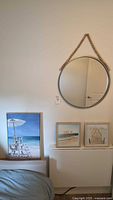 Mirror and three framed artworks displayed on wall and shelf