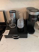 Keurig brewer on pod drawer, Magic Bullet base with two cups visible