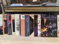 Front view of all twelve album jackets lined on carpet