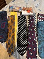 Overview of nine neckties and two boxed bow ties