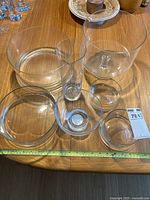All six glass vessels on table with tape for scale