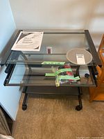 Full view of glass computer cart showing frame, shelves and casters