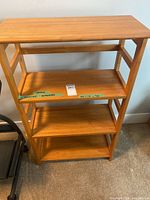 Front view of light wooden shelving unit showing shelves and overall condition