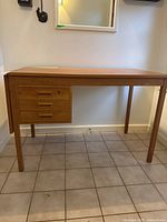 Full view of teak veneer desk showing drop leaf, drawers, legs