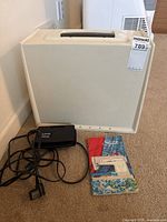 Sewing machine closed in carrying case with foot pedal and manual beside