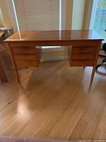 full view of teak veneer desk showing tapered legs and drawer pedestals