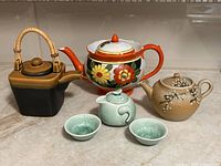 Group shot showing all four teapots and two cups