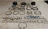 All 41 bracelets laid out: bangles, cuffs, stretch and clasp types