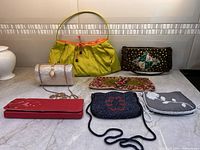Group shot of seven handbags and clutches