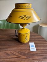 Front view of yellow toleware lamp on table