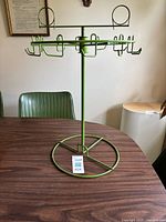 Full view of green metal jewelry tree on table