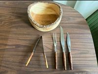 Group shot of wooden bowl and four utensils on table