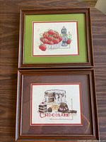 Both framed cross-stitch pieces side by side showing frames and mats