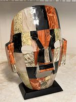 Front view of mosaic abalone and stone Aztec style mask on stand