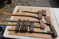 All axes, axe heads, and wedges laid out on cardboard