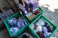 Four green crates containing epoxy boxes and numerous bags of glass gems