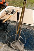 Two antique fishing rods with reels on table