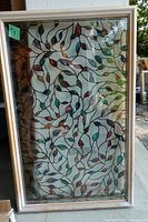 Full view of glass window insert with decorative leaf film and plastic frame