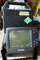 front view of fish finder in cradle showing screen and keypad