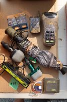 All items laid out: Primos bugle, cow call, diaphragm reeds, SpyPoint caller, remote, sound cards, rangefinder
