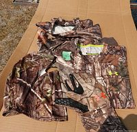 Group shot of both shirts, gloves and balaclava laid on cardboard