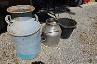 Three containers: blue steel milk can, stainless steel milk can, black rubber pail